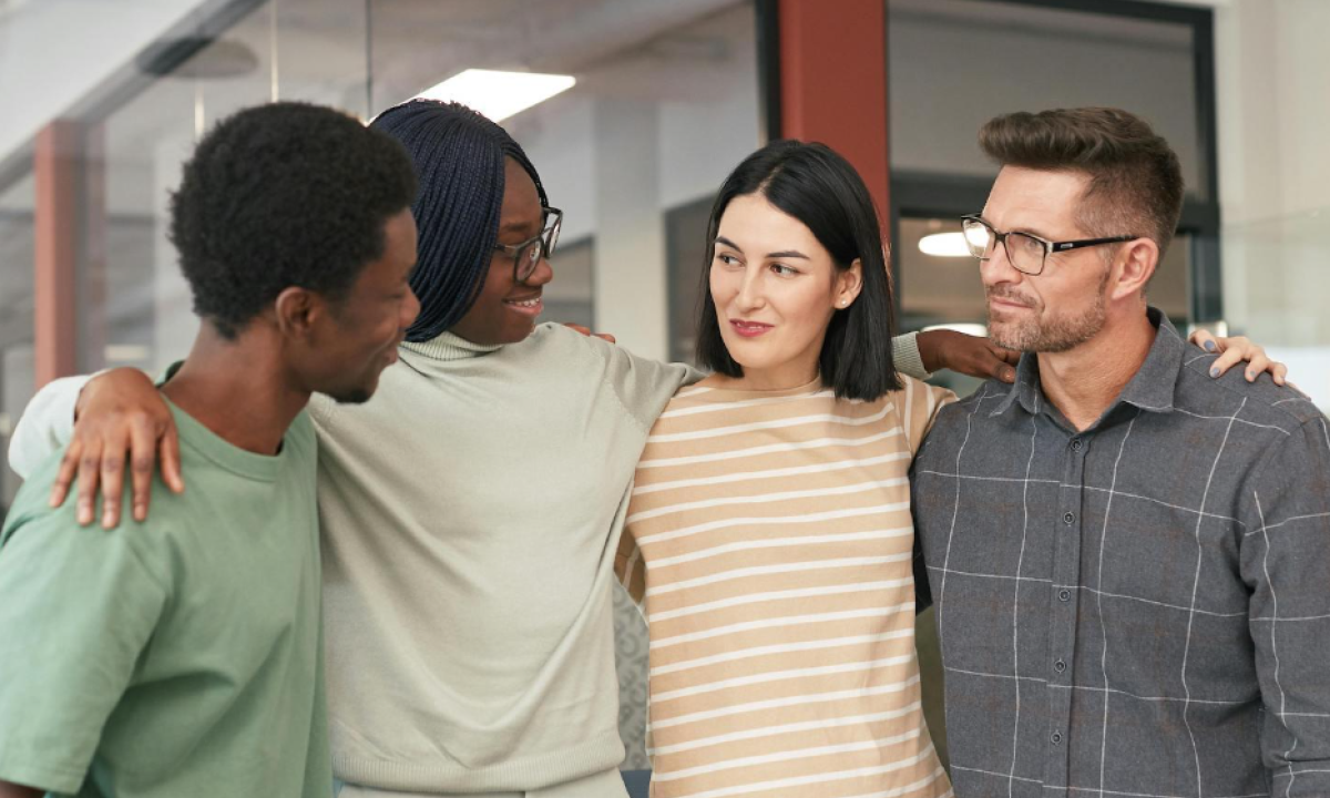 four people coming together to embrace 