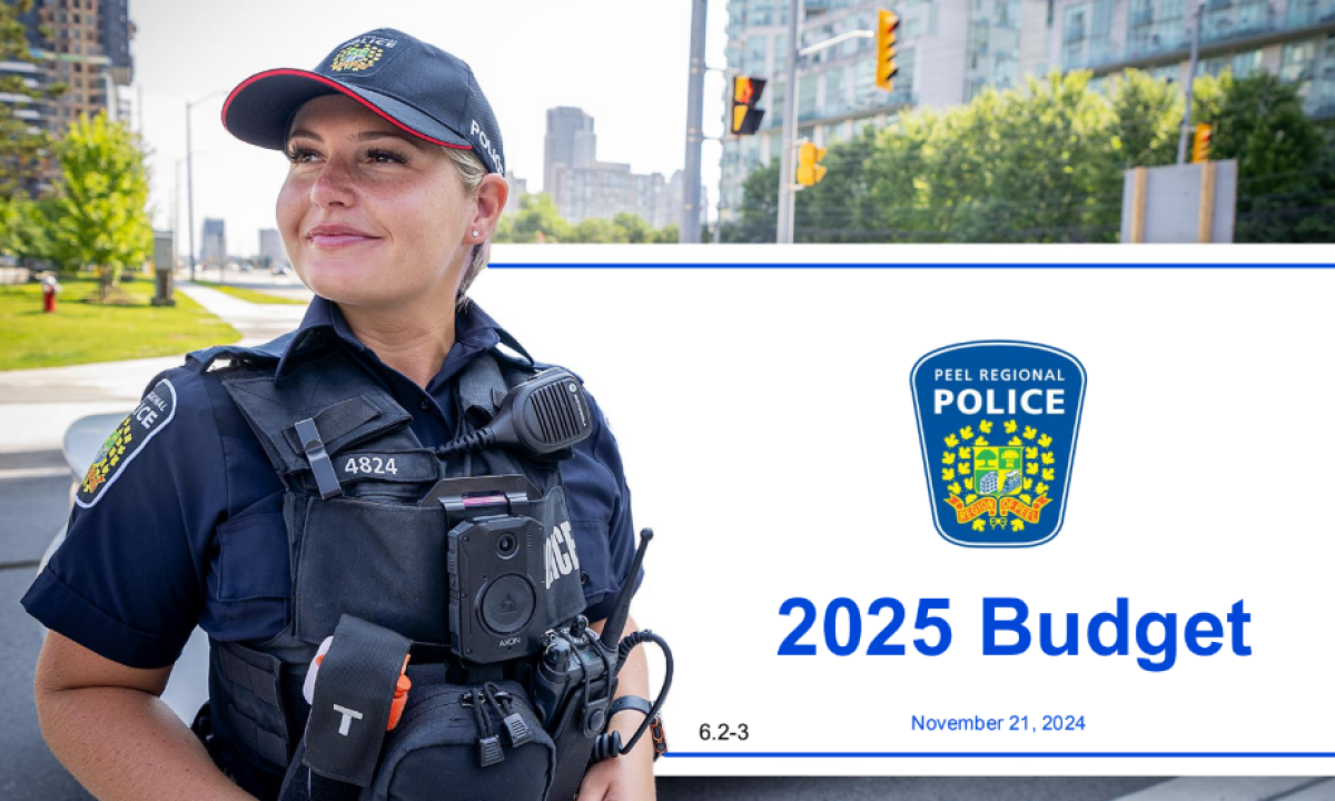 Police officer in community standing in front of the banner of the 2025 Peel Region Police Budget