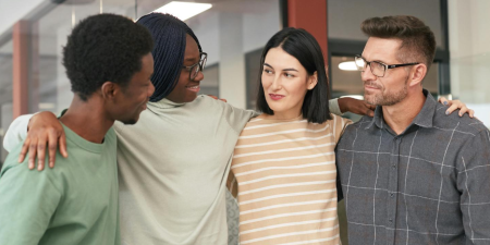 four people coming together to embrace 