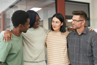 four people coming together to embrace 